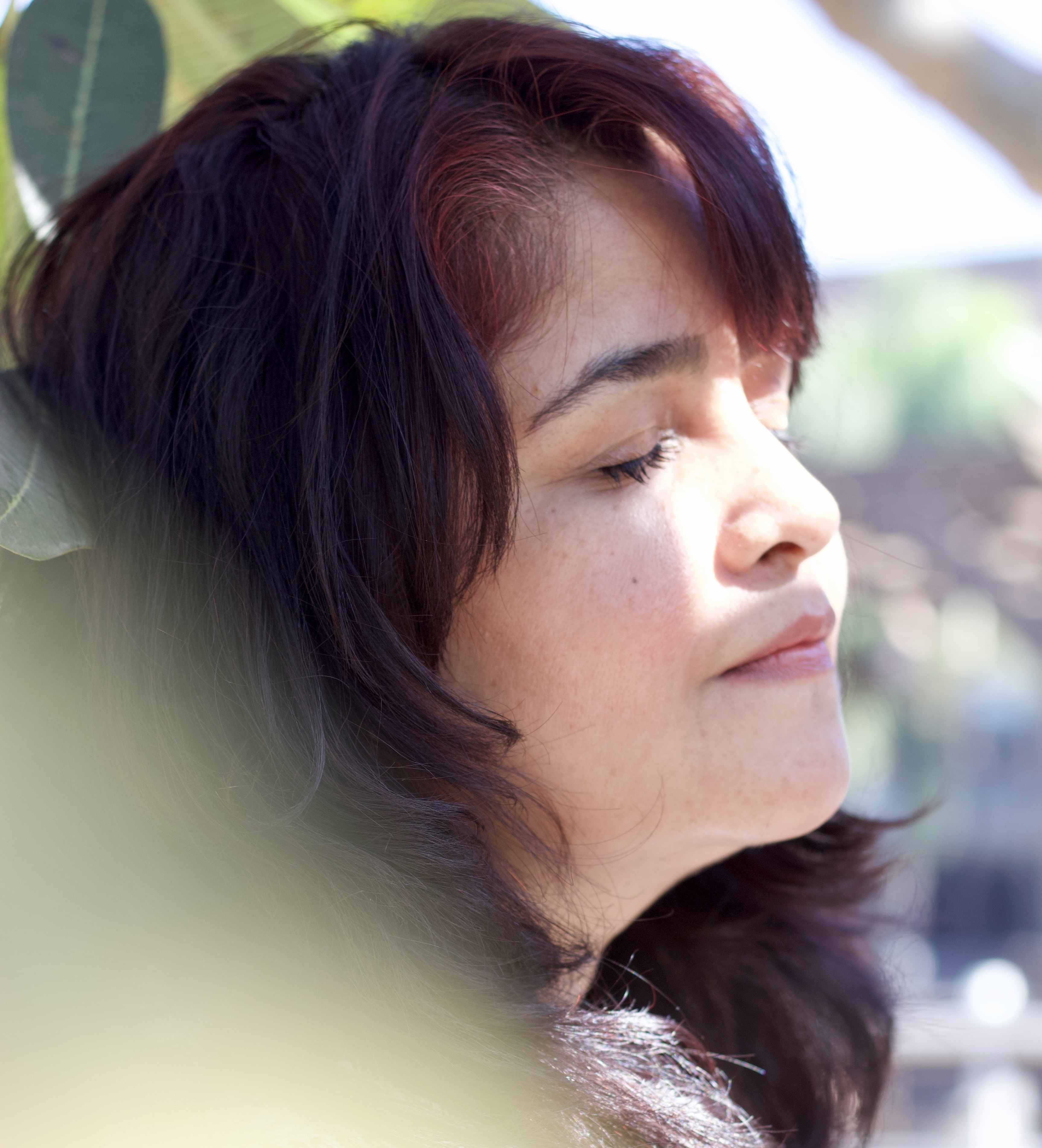 Aditi Nirvaan - Warm, side-lit portrait showing a present, peaceful, grounded presence